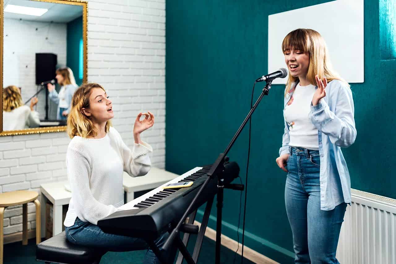 Vocal coach training her student's voice on a lesson